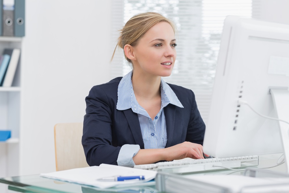 Young-business-woman-working-on-computer-at-desk-in office