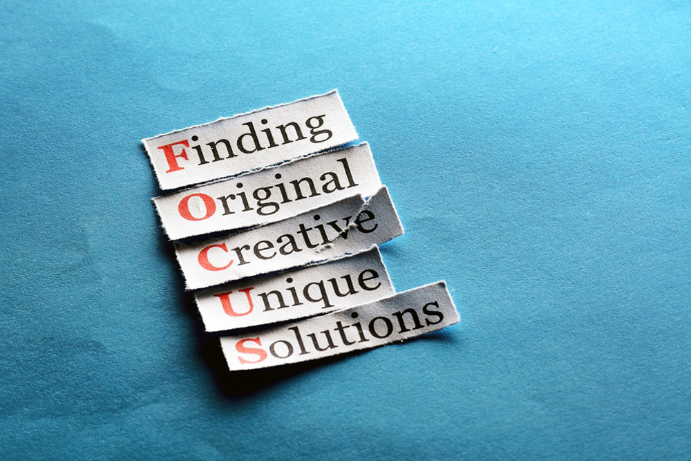 Refresh Your Business 2 - printed paper on blue background with text Finding Original Creative Unique Solutions