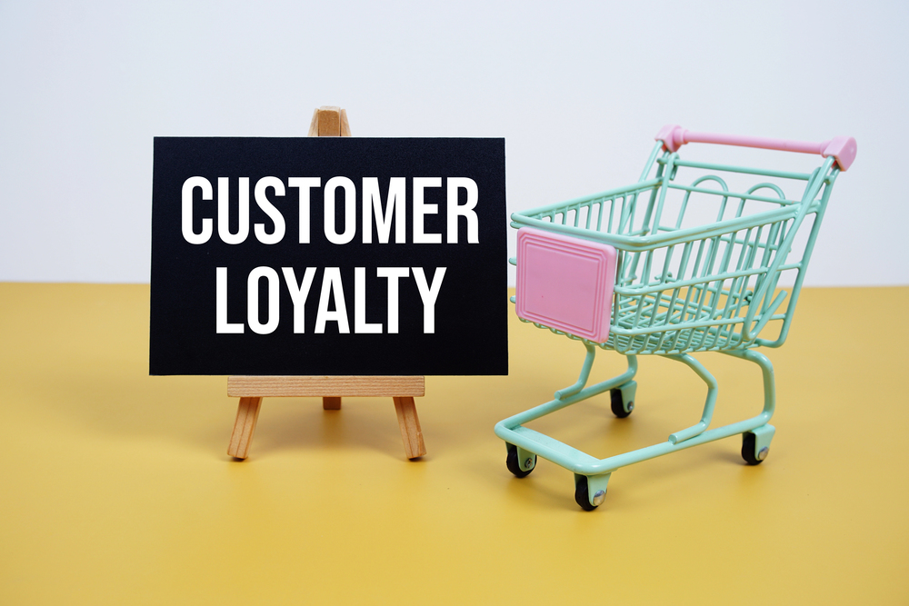 green and pink shopping cart with sign with text Customer Loyalty representing strategies to build loyalty