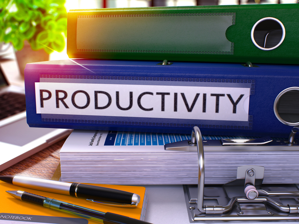 various binders on a desk on top of an open binder with the title productivity representing Tips on Using AI to Boost Productivity in Your Small Business
